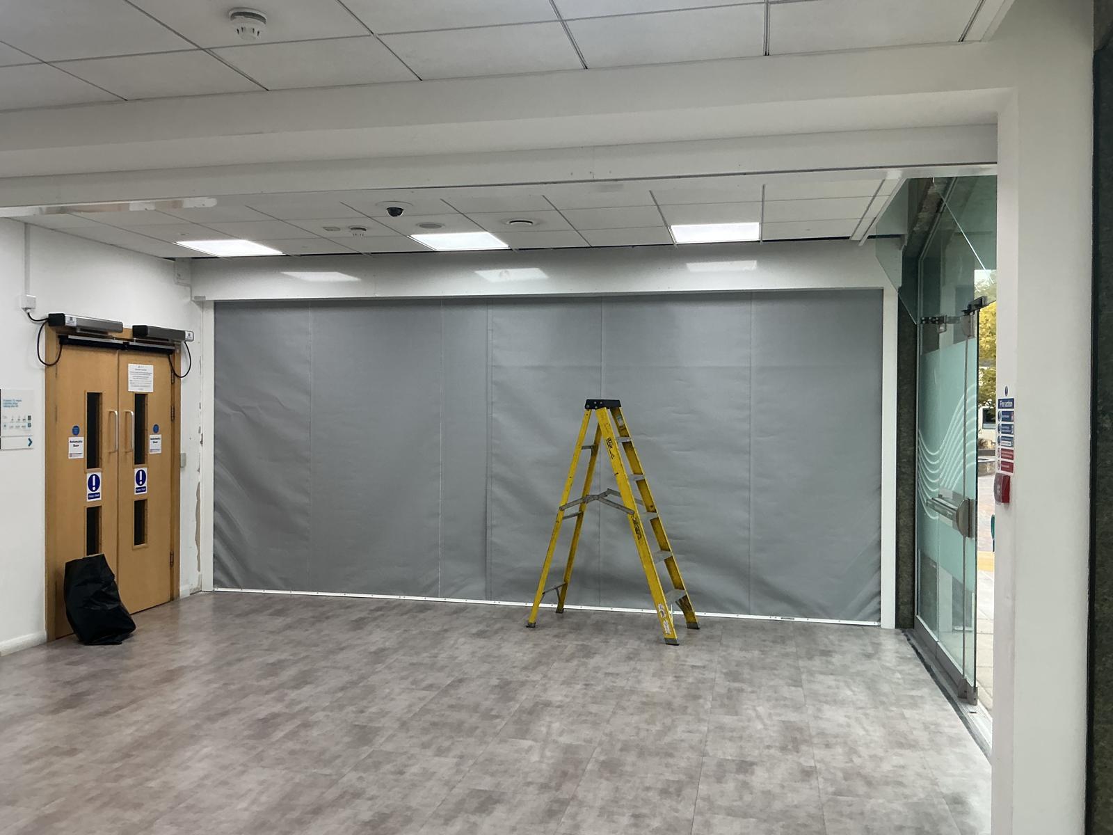 Fire curtain descended across a wide interior opening during commissioning
