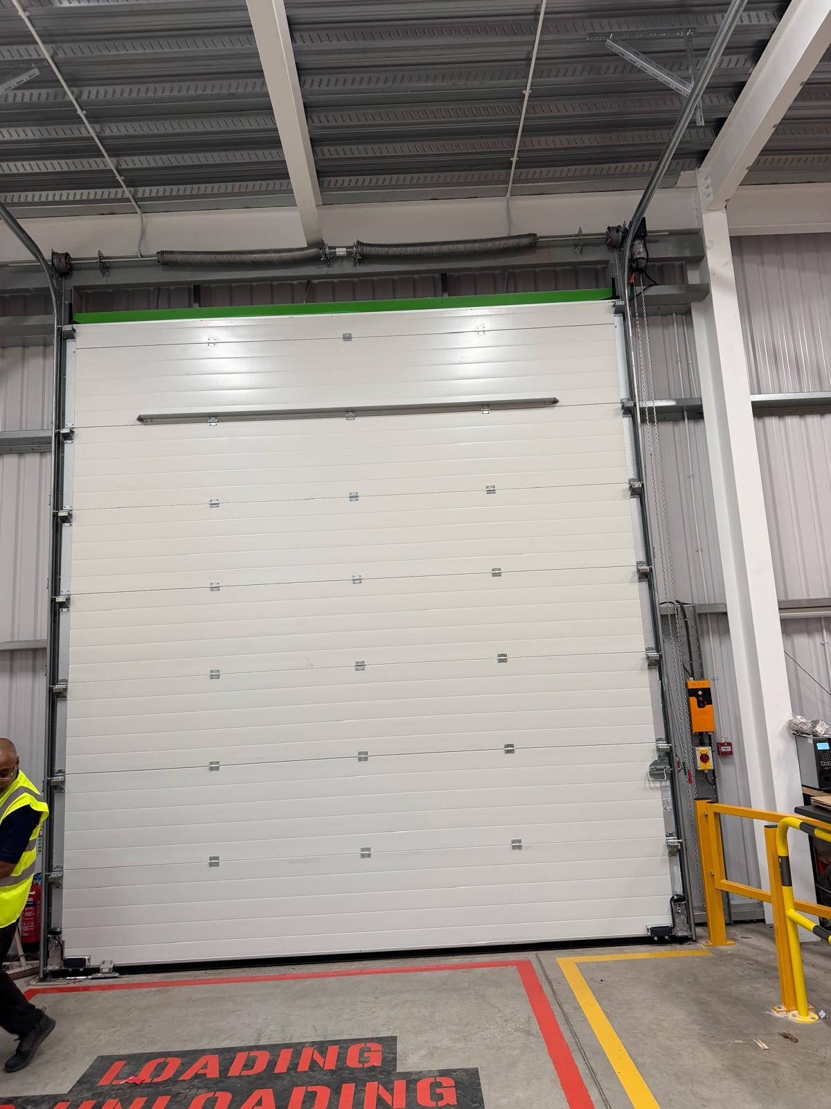Industrial door installation underway on a large commercial opening