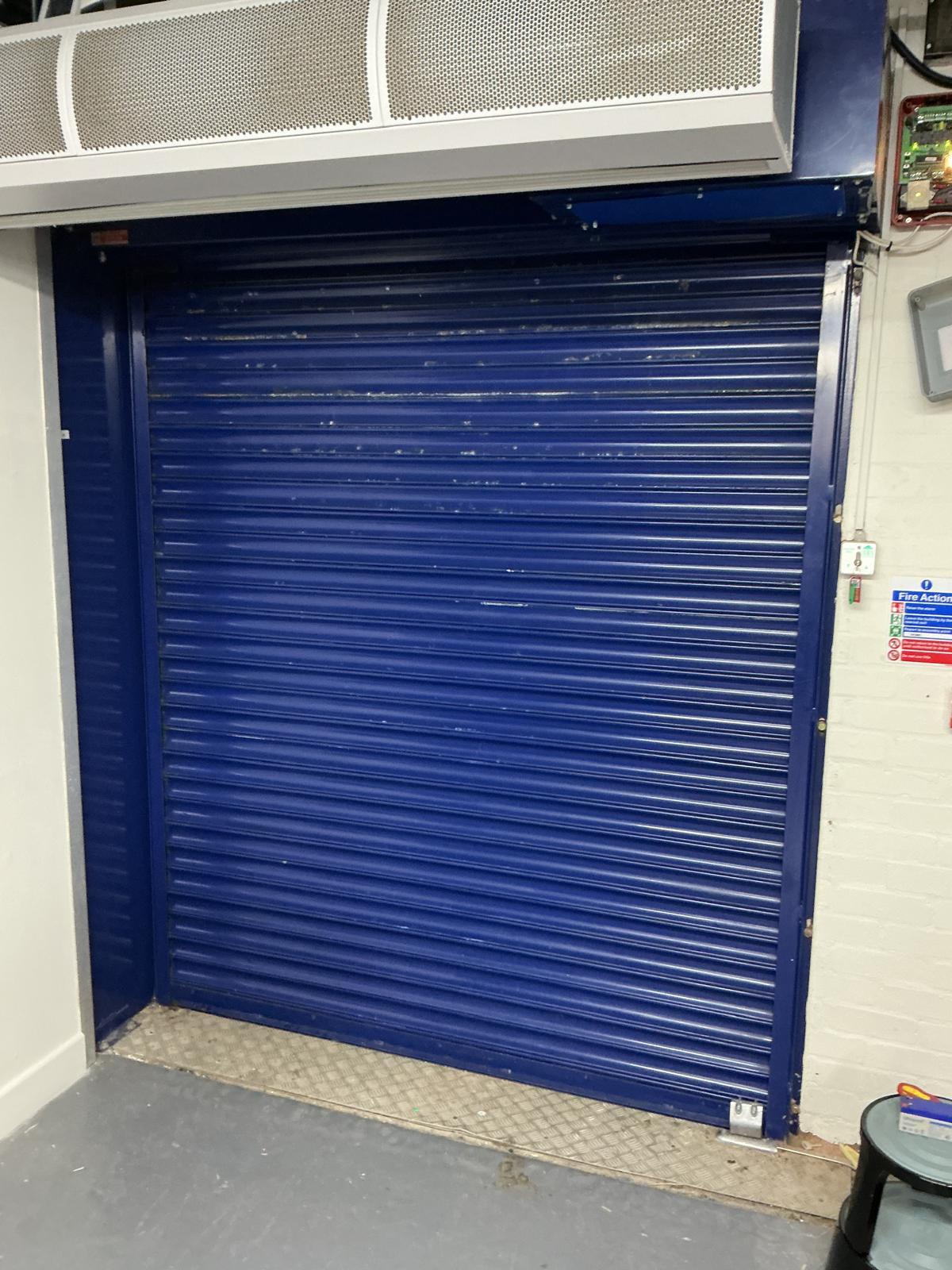 Roller shutter powder-coated blue, closed on a commercial frontage