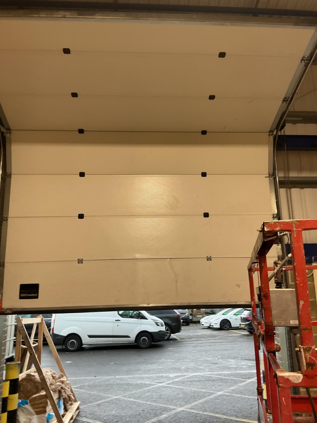 Sectional overhead door seen from inside, panels stored above the opening